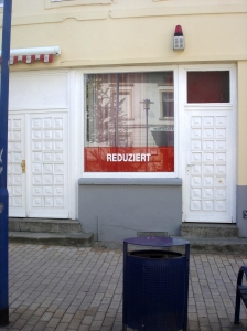 Schild "Reduziert" im Schaufenster - Trödlerin Jenny erzählt aus ihrem Alltag auf dem Marheinekeplatz